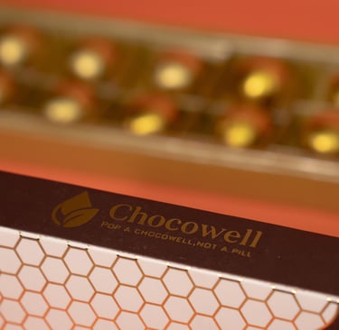 Box of Chocowell chocolate supplements with gold foil-wrapped balls in a gift tray.