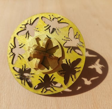 Wooden spinning top painted yellow with bee cut outs