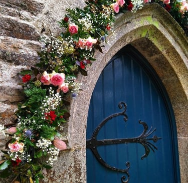 blue church door with flowers around the arch