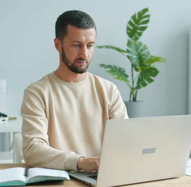 a man sitting at a desk with a laptop computer