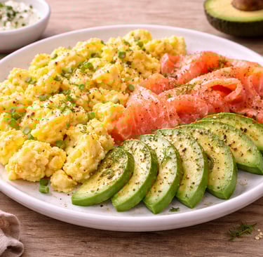 Huevos revueltos con salmón ahumado y aguacate, desayuno saludable alto en proteína servido en un pl