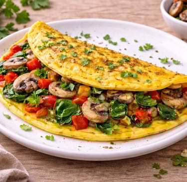 Omelette de huevos con verduras como pimiento, espinacas y champiñones, desayuno saludable alto en p