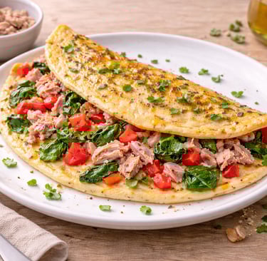 Tortilla de huevos con atún y verduras, desayuno saludable alto en proteína servido en un plato blan