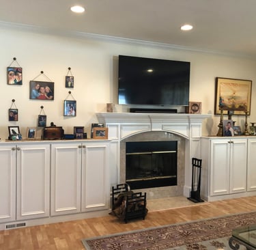 Custom fireplace surround with built-in cabinets and crown molding
