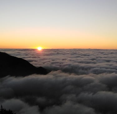 a sunset over a mountain range with a sunset