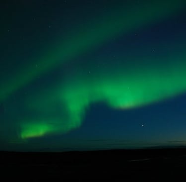 a green and blue sky with a bright green light in the background