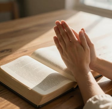 Praying hands gently clasped together with a soft glow surrounding them.