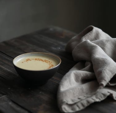 Minimalist winter food scene with a simple ceramic bowl of warm soup on a dark rustic wooden table