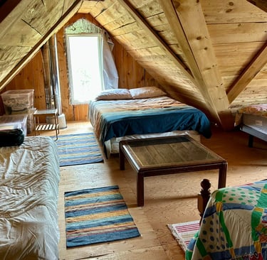 Lit dortoir dans la mezzanine d'une cabane en bois.