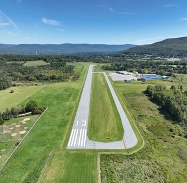 Aerial view of William H. Morse State Airport in Bennington, VT surrounded by fields and mountains.
