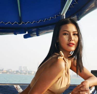 Stilvolle Frau im beigen Badeanzug genießt eine luxuriöse Yachtkreuzfahrt bei Sonnenuntergang