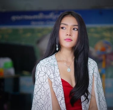 Elegante Frau mit langen dunklen Haaren, die ein rotes Kleid und ein weißes florales Capelet trägt