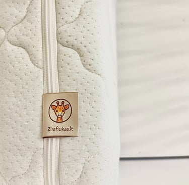 čiužinio dalis baltame fone su aiškiai matomu zirafiukas.lt logotipu