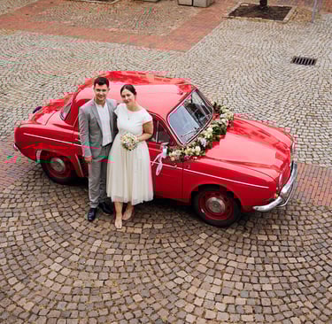 Smiling father giving a toddler in a purple snowsuit a shoulder ride outdoors in winter.