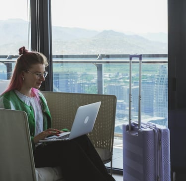 Two women on a rooftop balcony with city views, one holding a cocktail, enjoying a celebration with flowers and drinks.
