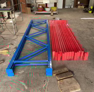 Assembled steel pallet racking uprights and horizontal beams positioned side by side.
