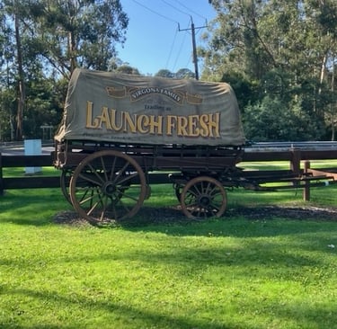 an old wagon cart with a canvas top launch fresh written on the side of the canvas located in launching place
