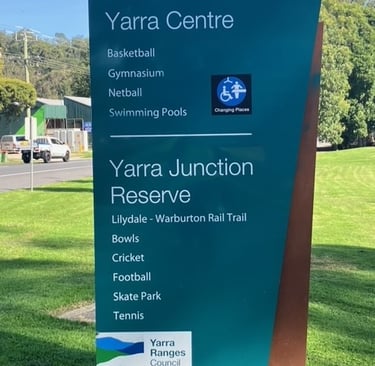 green sign beside the warburton highway in yarra junction sign reads yarra junction reserve and yarra centre 