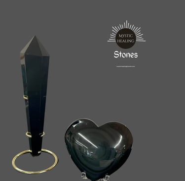 Polished black obsidian tower on a gold stand and a smooth heart-shaped healing stone crystal.