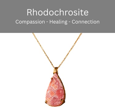 A teardrop-shaped pink rhodochrosite crystal pendant on a delicate gold chain necklace.