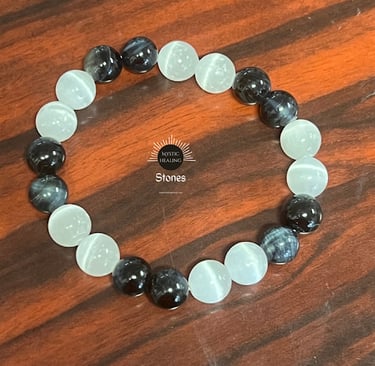 Handmade stretch bracelet featuring alternating black and white cat eye glass beads on a wood surfac