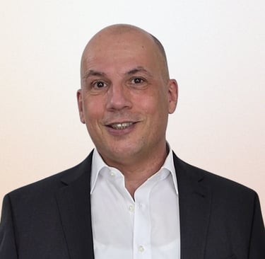 Professional Heinz Roelfs in a black suit and white shirt smiling for a business headshot.