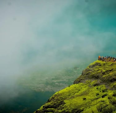 Lush green mountains and valleys covered in deep mist at Raigad Fort during the monsoon season.