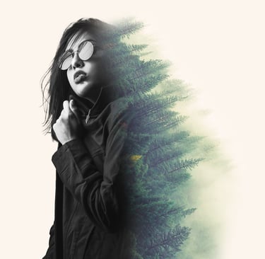 Double exposure portrait of a woman in sunglasses blended with a pine forest landscape.