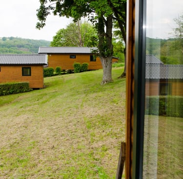 Rustieke houten hutten op een grasrijke heuvel, gelegen in een resort met uitzicht op de bergen