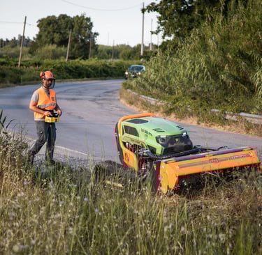 Green Climber LV 500 Pro clearing vegetation along road side, operator safely behind
