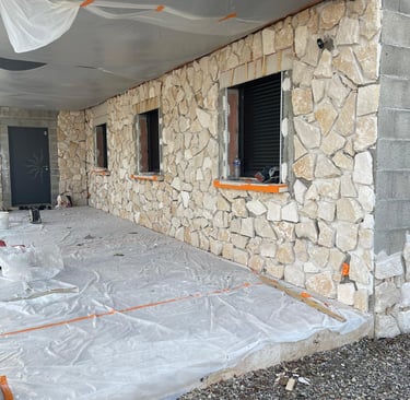 a house being built into a house with a large stone wall