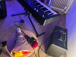 Corner of teaching studio showing digital piano and a bouquet of flowers for students after recital