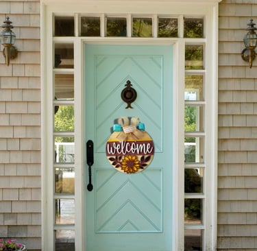 A home decor door hanger with a colorful bow that says "Welcome" hanging on a home door.