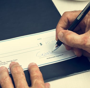 Home Seller writing a real estate commission check to his realtor