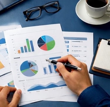 Un hombre analiza informes de datos con gráficos circulares y de barras en un escritorio..