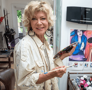 Portrait de Patricia Pierrard, artiste peintre expressionniste, avec palette et pinceau dans atelier
