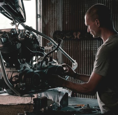 man working on his motorcycle engine
