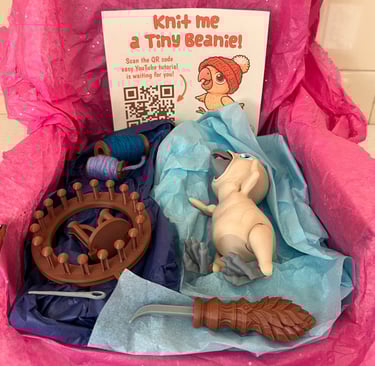 Baby parrot with 'knit your own' bobble hat, knitting loom, needle, wool and knitting hook