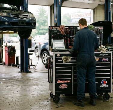 Auto mechanic in blue coveralls using a laptop at a tool chest to get strategic insights on how to .