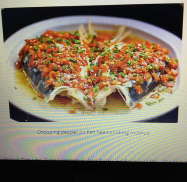A plate of cooked fish and red peppers.