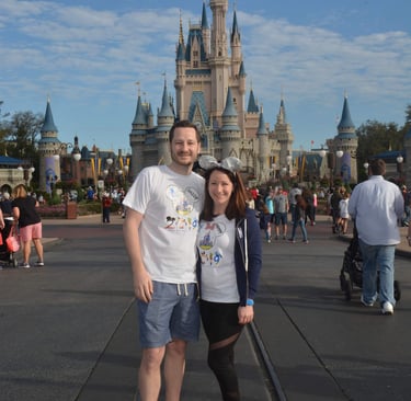 Couple standing in front of Cinderella's Castle at Walt Disney World