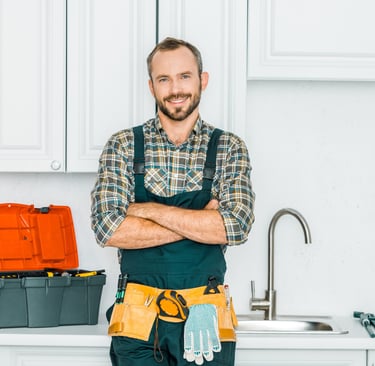 Professional home repair technician standing in a residential kitchen with tools