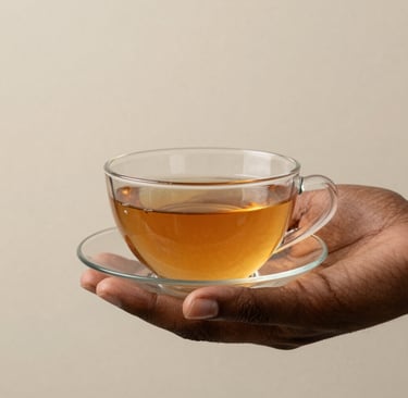 Hands gently holding a warm cup of herbal tea with steam rising against a soft background