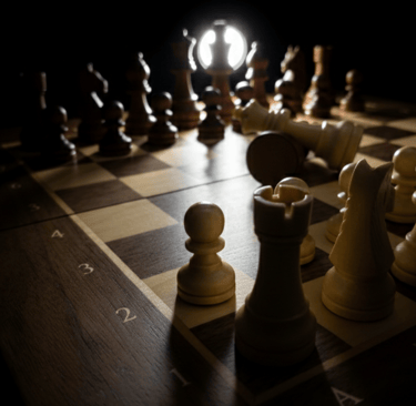 A wooden chessboard with pieces in a dramatic spotlight, featuring a fallen white king.