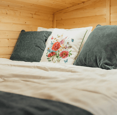 Tiny house double bed with green pillows