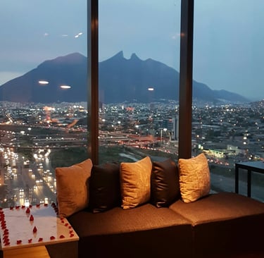 Asientos de salón de lujo con una vista panorámica de las luces de la ciudad de Monterrey y el Cerro