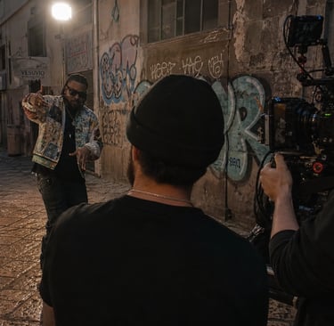 Produção de videoclipe profissional com equipa filmando artista em cenário urbano