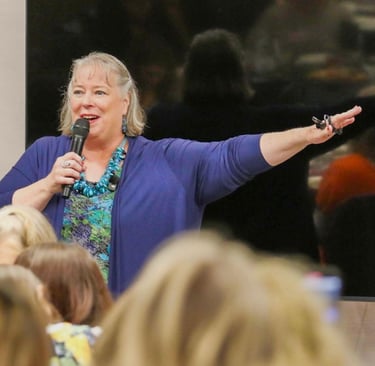 Debbie Chen speaking to an audience with a microphone, Business Leadership Coach and speaker.