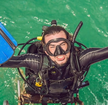 Lachender Taucher im Wasser mit blauer Flosse