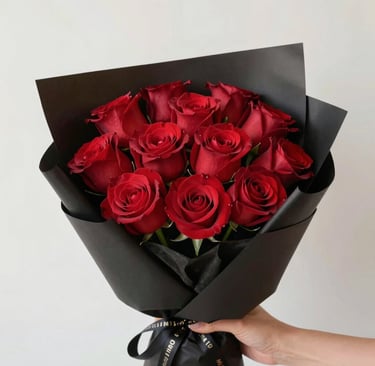 A close-up of vibrant red roses with dewdrops on the petals.